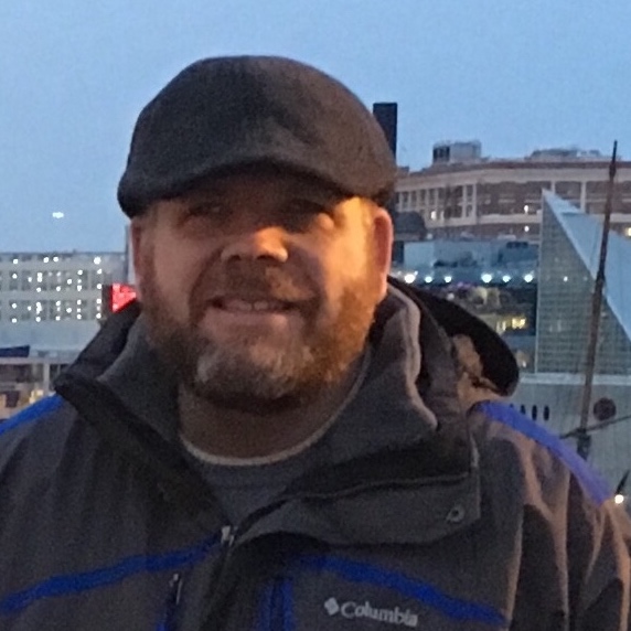 Head shot of A.W Stephens with Baltimore Harbor in the distance